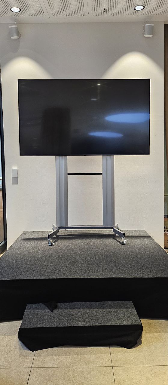 Großer Monitor auf professionellem Rollständer auf einer beleuchteten Event-Bühne