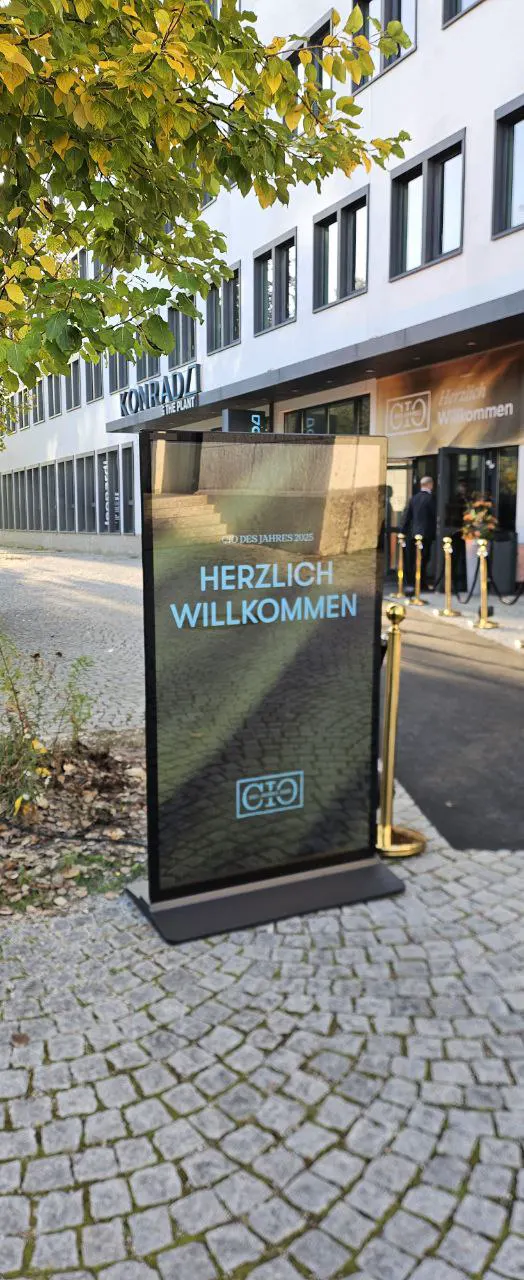 Outdoor-Stele begrüßt Gäste vor einem Eingang